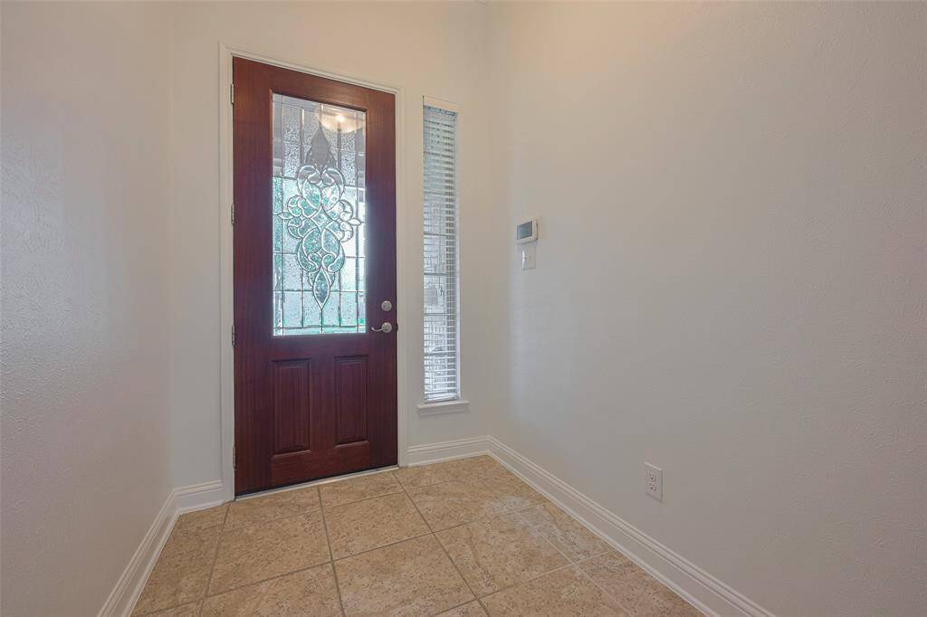 Glass-paneled front door with a sidelight adds a bright welcome.