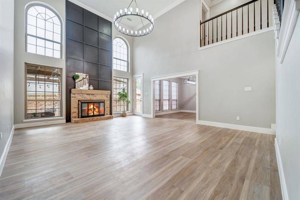 This beautiful living room has souring ceilings and large open windows for natural light.