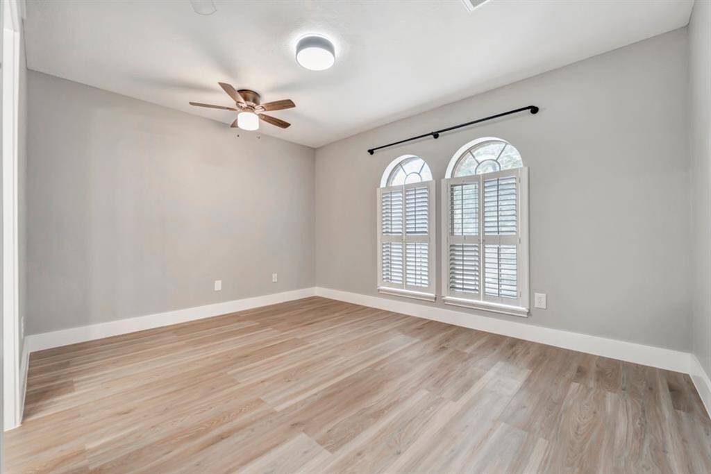 The secondary bedroom has large windows with natural lighting.