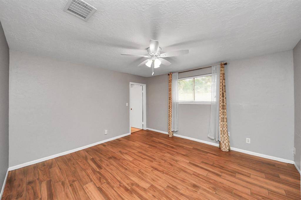 Expansive primary bedroom with fresh paint and a ceiling fan.