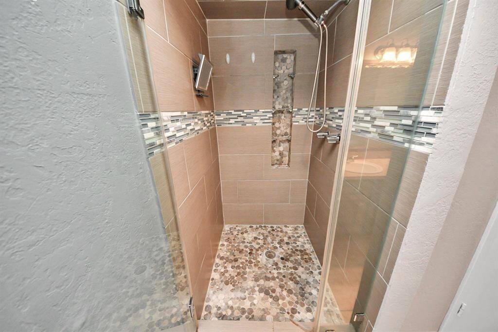 Luxuriously upgraded tiled shower with modern finishes.