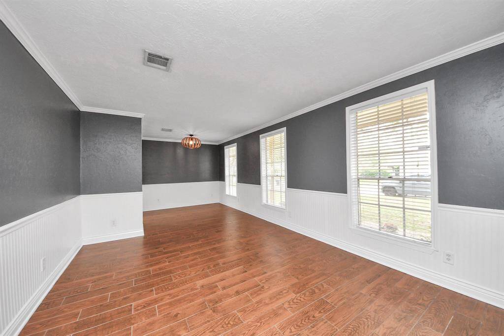 Bright and inviting, this living-dining area features abundant natural light and elegant hardwood floors.