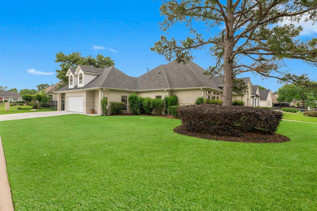 View of this charming home from the street corner showcasing the spacious, well-maintained lawn and mature landscaping. Features a three-car garage and attractive dormer windows, offering classic curb appeal in a quiet neighborhood! Plenty of parking for your guests!