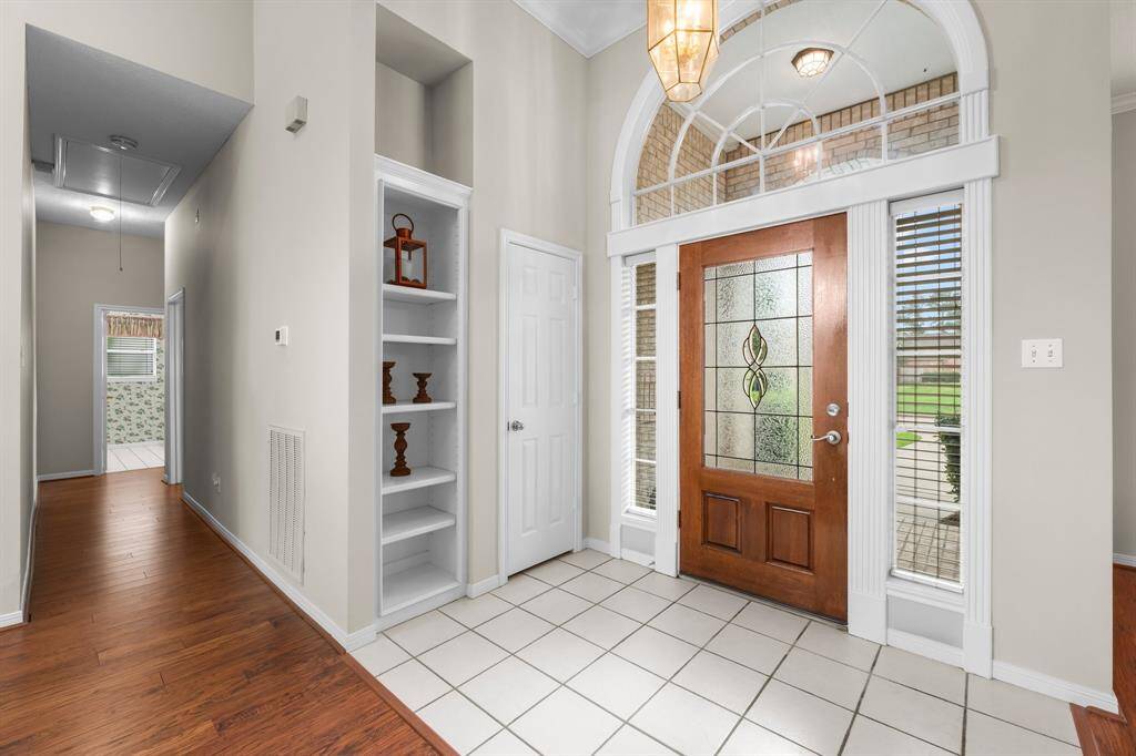 Inviting entry with elegant tiled flooring, fresh paint, and a beautifully stained door.