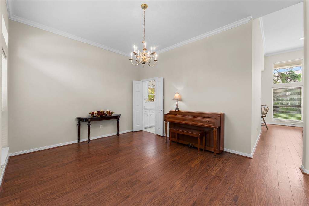 Formal dining room is spacious and features wooden flooring and double doors into the kitchen. Three large windows offer views to the front yard and the vacant lot across the street.