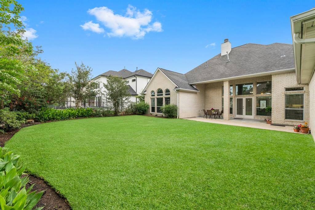 After a long day on the Golf Course or on the Lake, escape to your own spacious backyard with a well-maintained lawn and a large patio area, perfect for outdoor dining and entertaining. The home features a modern exterior with large windows, providing ample natural light. Surrounding greenery adds privacy and a touch of nature.