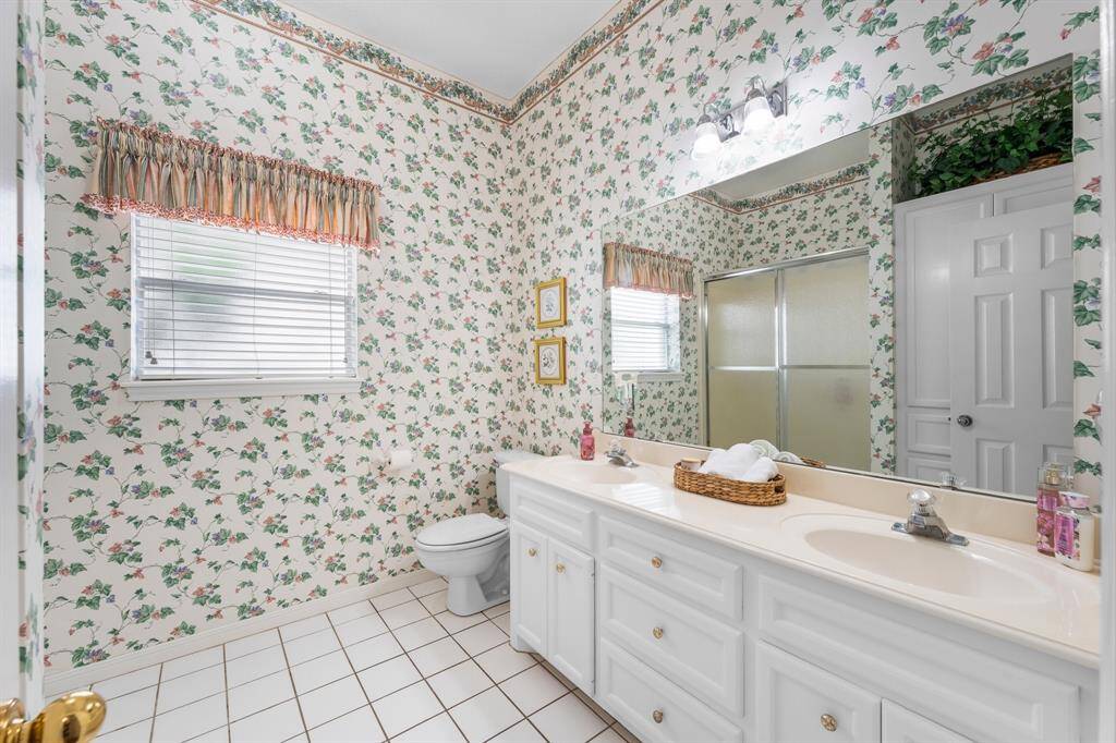 Second floor bath with custom cabinets, dual sinks, and built-ins, including a laundry hamper.