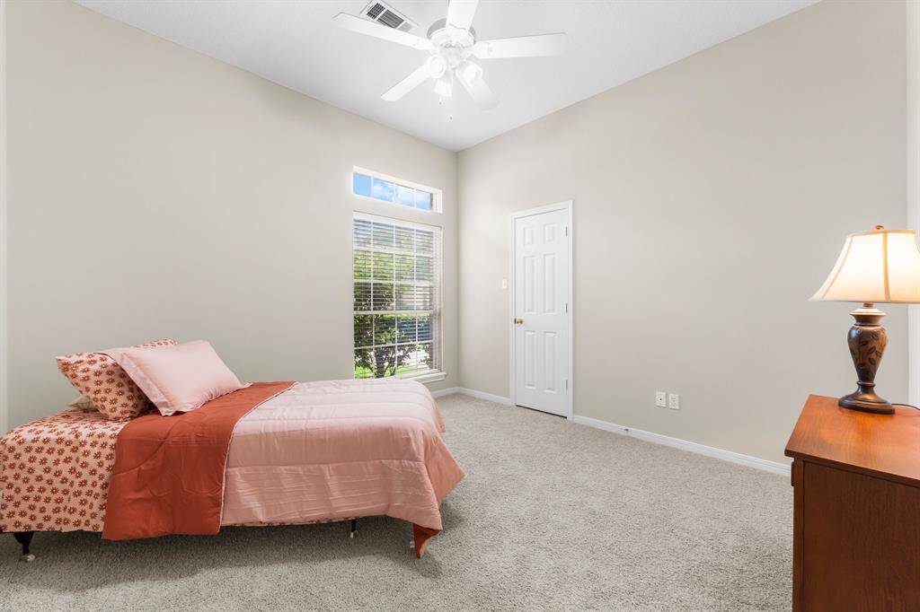 Third full bedroom, located near the front of the home features high ceilings, brand new neutral paint, new carpet, walk-in closet, and a ceiling fan!