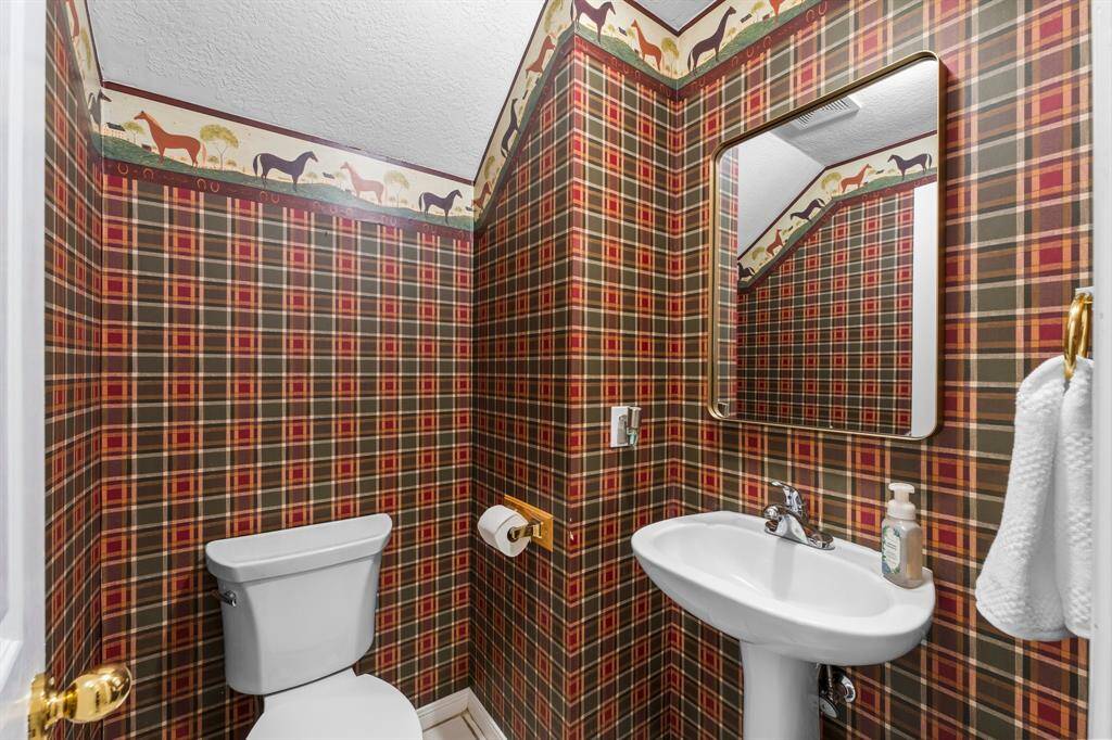 Powder bath tucked in the utility area under the stairs that lead to the huge upstairs flex room.