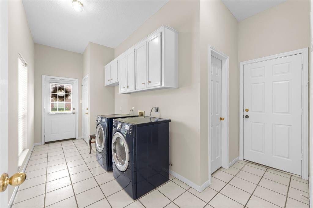 Side entry from driveway into utility room to left and entry from attached garage to the right with powder bath behind cabinet wall. Natural light and another closet behind open door.