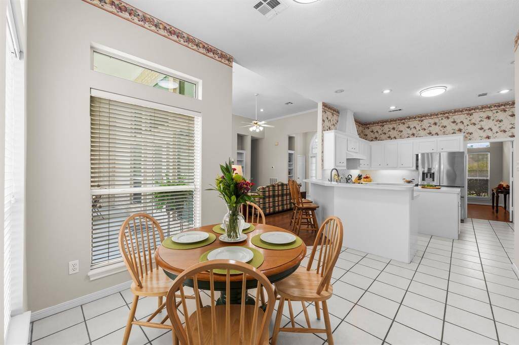 This bright, open-concept kitchen and breakfast area features fresh painted walls and cabinetry, a breakfast bar and large windows that offer plenty of natural light and great views into the back yard and patio. Open Concept that extends into a comfortable living area.