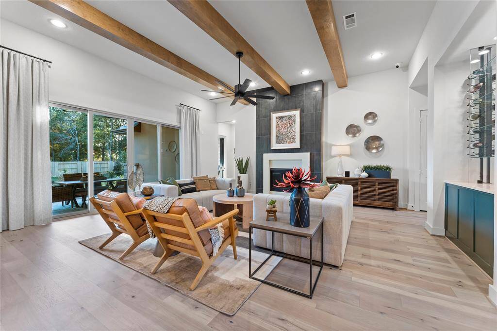 Family Room with Wood Beam Ceiling, Gas Fireplace, and Sliding Doors to the Covered Rear Patio