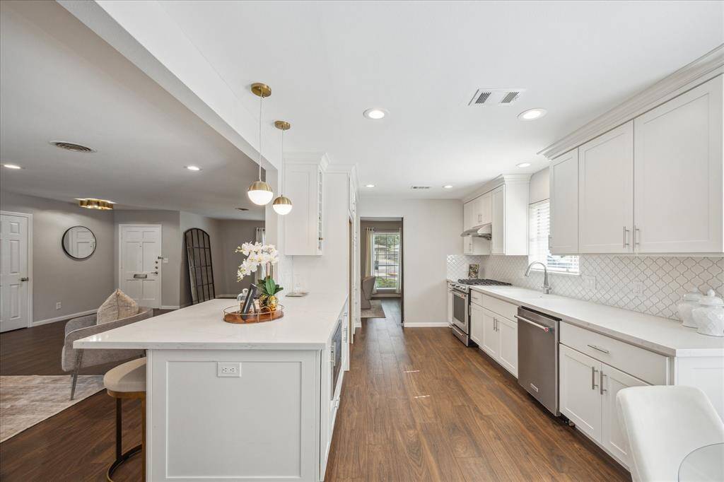 Kitchen features stainless steel appliances, large farmhouse sink, ample storage, wine rack, pantry, and more!