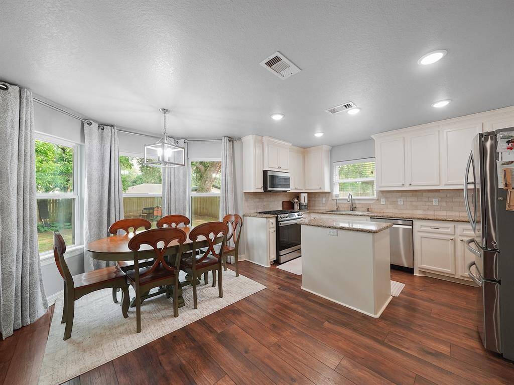 THIS PHOTO SHOWS THE SUNNY & SPACIOUS DINING AREA WHICH FEATURES SERENE VIEWS OF THE BACK YARD.