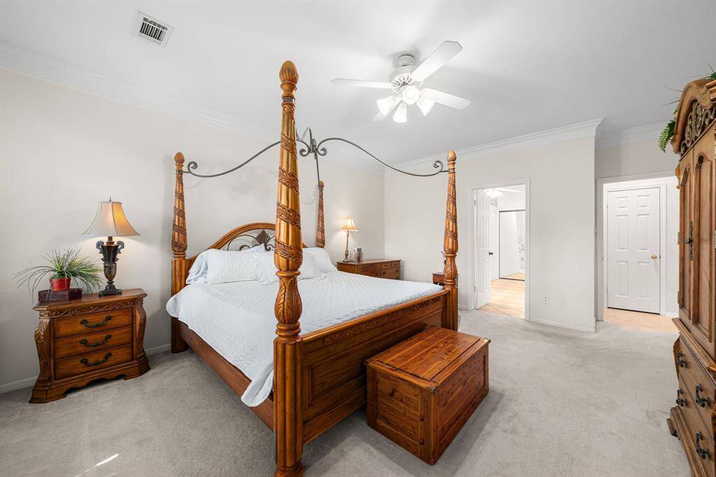 Neutral color palette ready for your personal touches, adorned with elegant crown molding and ceiling fan.