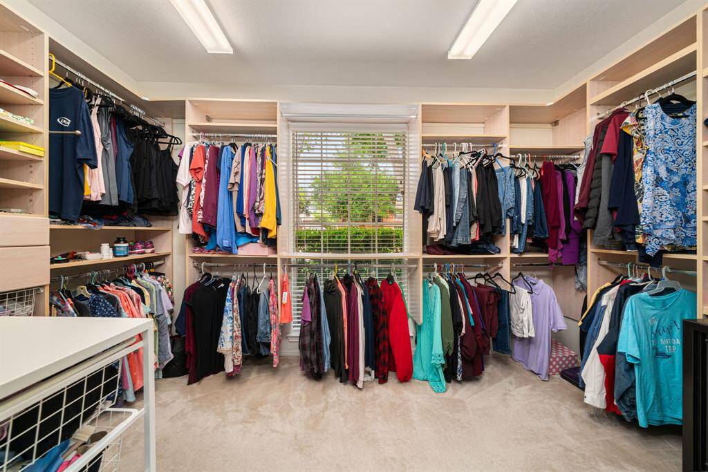 Spacious walk-in closet with ample shelving and hanging space, keeping you well organized with a large window allowing in abundant natural light.