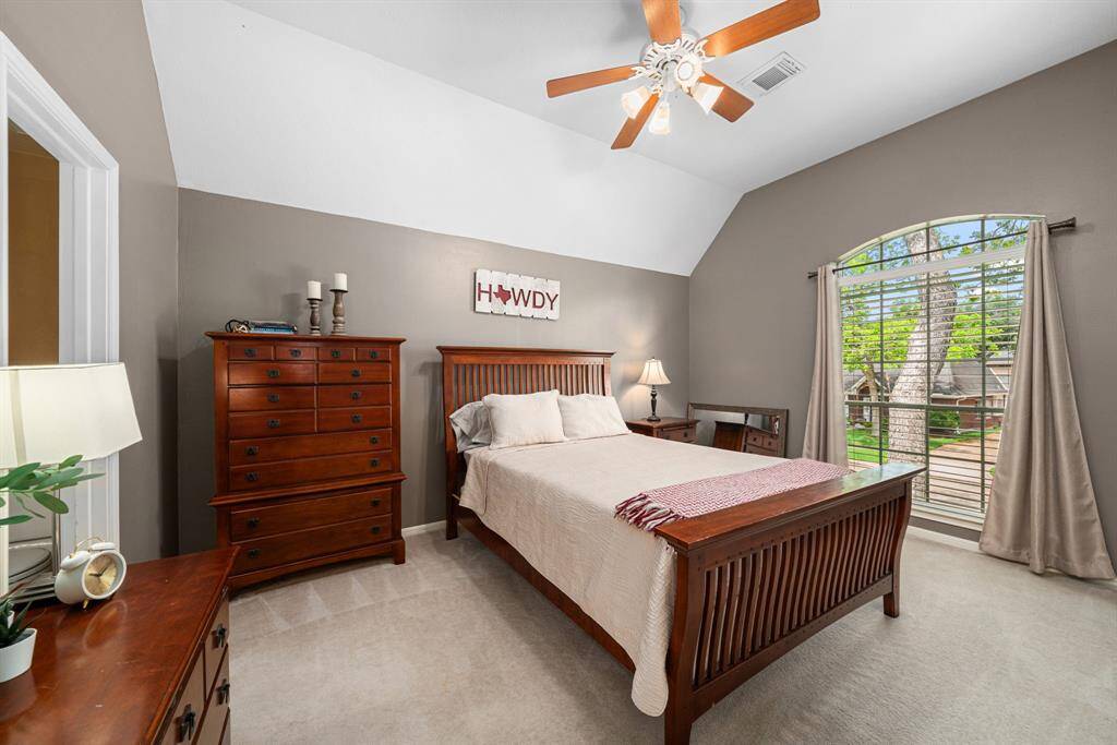 Spacious third bedroom features a vaulted ceiling, neutral tones, a fantastic window, and ceiling fan.