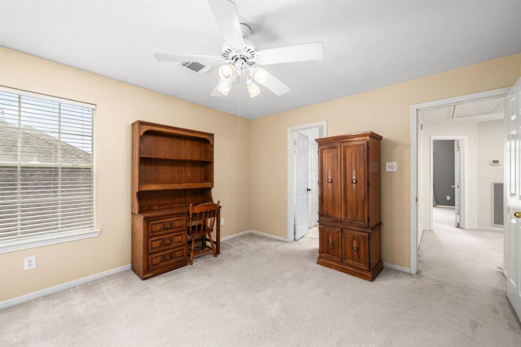 Fourth bedroom offers abundant space, neutral walls and carpet, and ceiling fan.