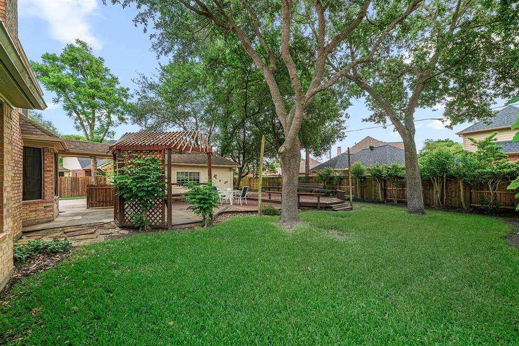 This large lot offers a spacious lawn with surrounding landscaping and trees.