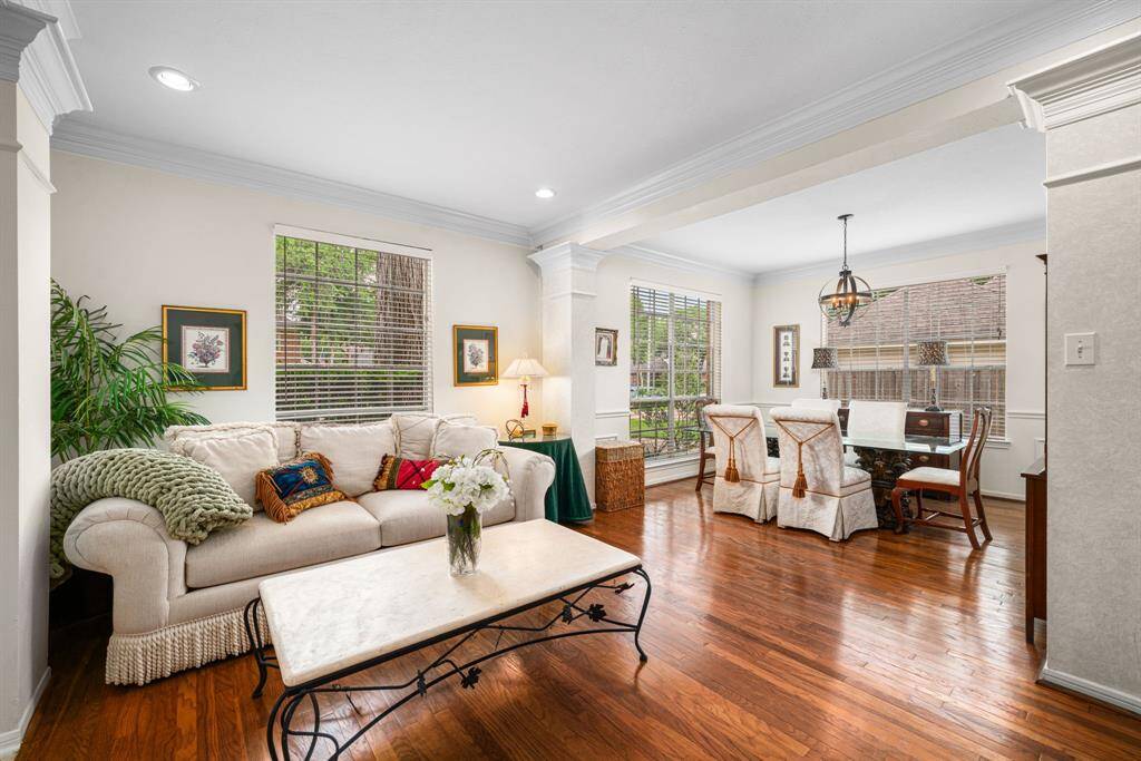 The open living space boasts large windows and elegant crown molding, offering a warm and welcoming atmosphere.