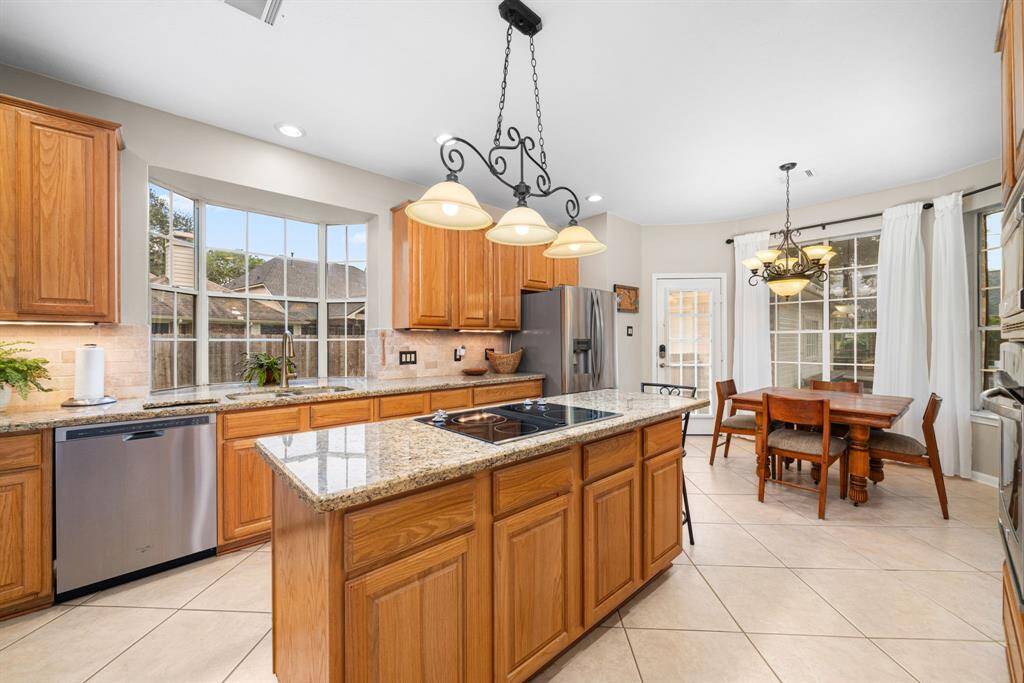 Bright and spacious kitchen with picturesque window over the sink, granite countertops, and attractive stainless steel appliances.