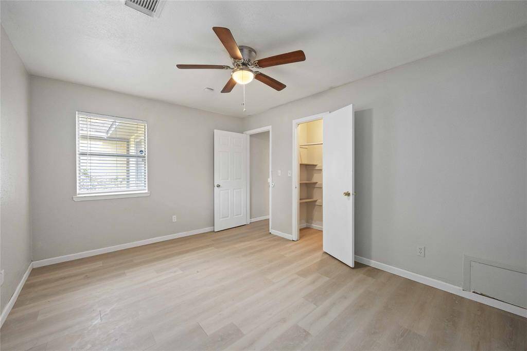 New flooring and fresh paint accompany the new ceiling fan in this bedroom