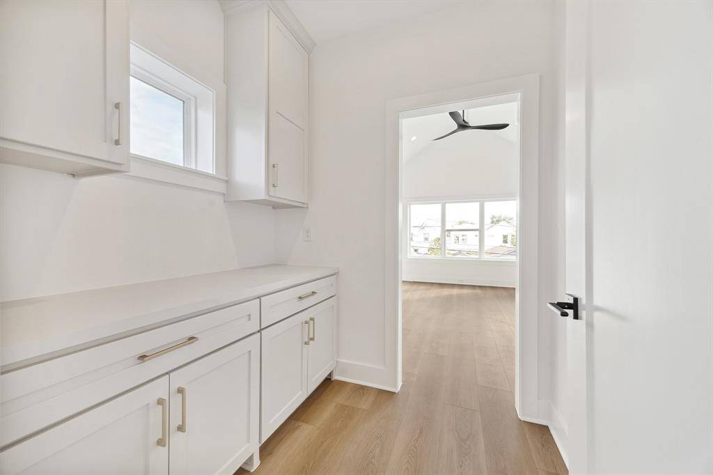 Private primary vestibule/dry bar upon entering the primary suite with storage, electrical outlets and transom window