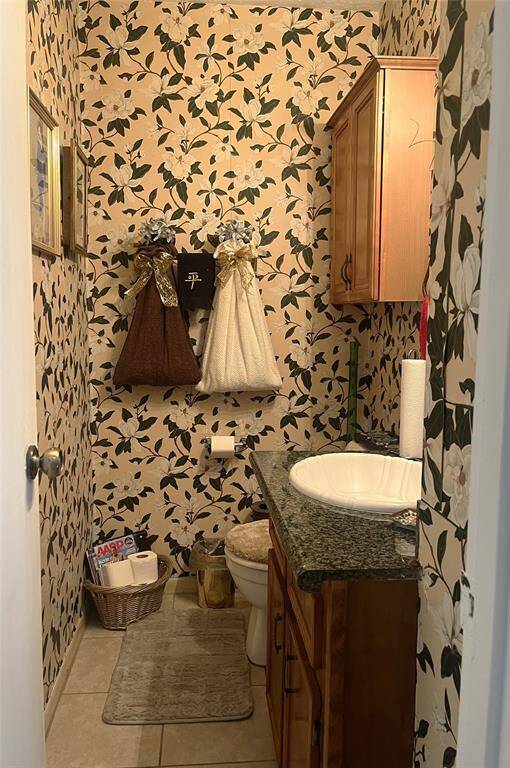 First floor half-bath with tile flooring and upgraded granite vanity.