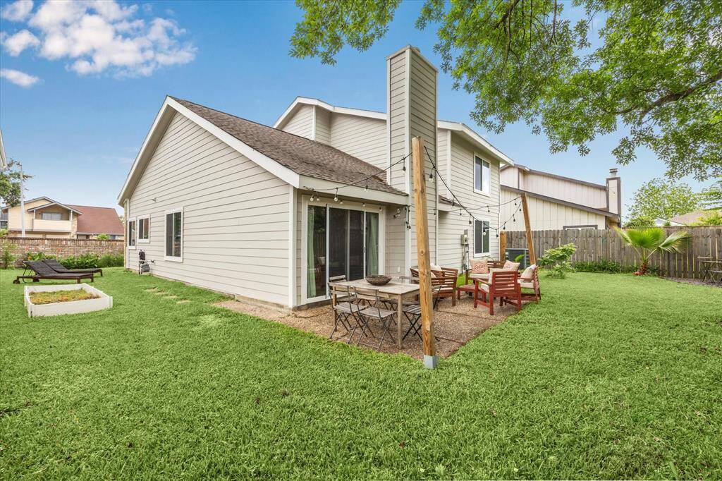 Generously sized and neatly landscaped back yard with mature trees and a privacy fence.