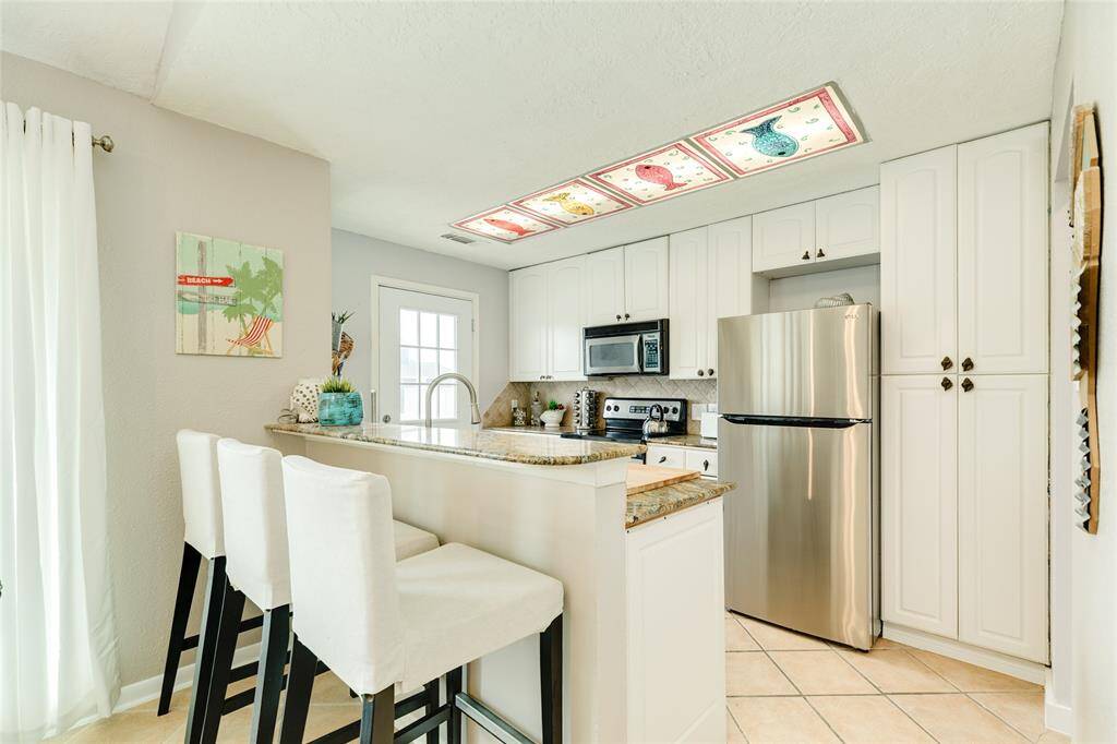 Breakfast bar in kitchen with stainless appliances.