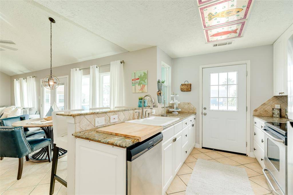 Kitchen with Granite countertops, stainless appliances with access to deck.