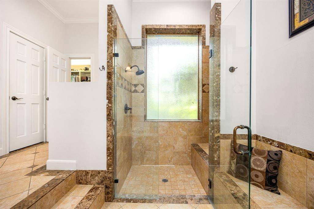 This additional view of the primary bath showcases a walk-in shower with tile surround and a separate garden tub perfect for soaking after a long day.