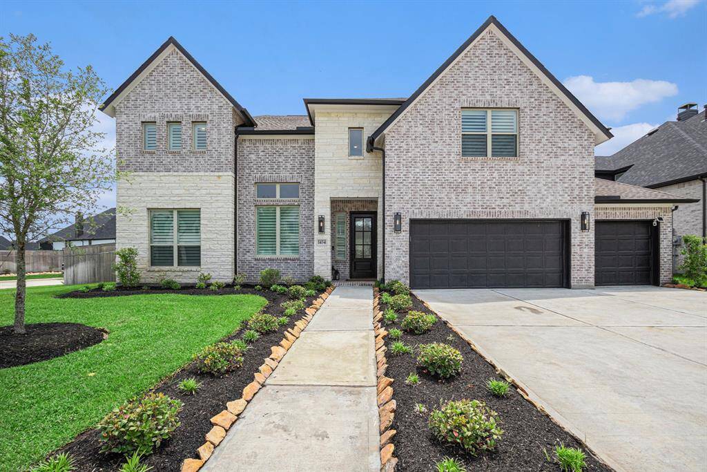 Beautiful curb appeal with its brick and stone exterior and landscaping.