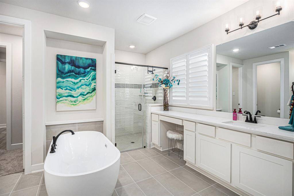 Primary ensuite bathroom with soaking tub and separate walk-in shower .