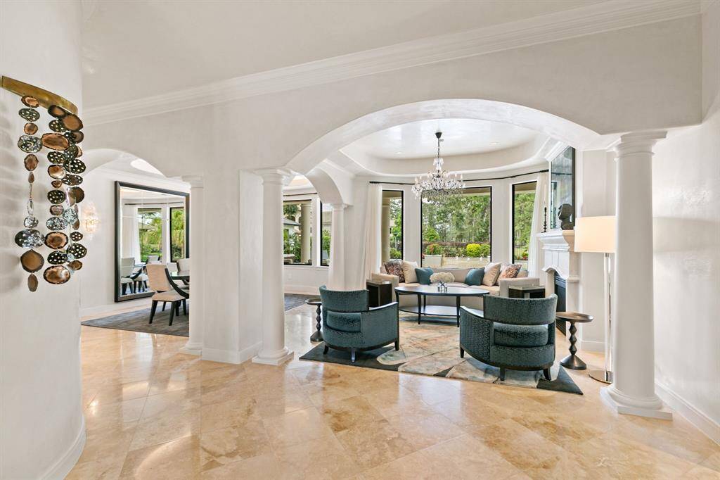 Both the formal living and formal dining feature large windows overlooking the resort-style backyard.