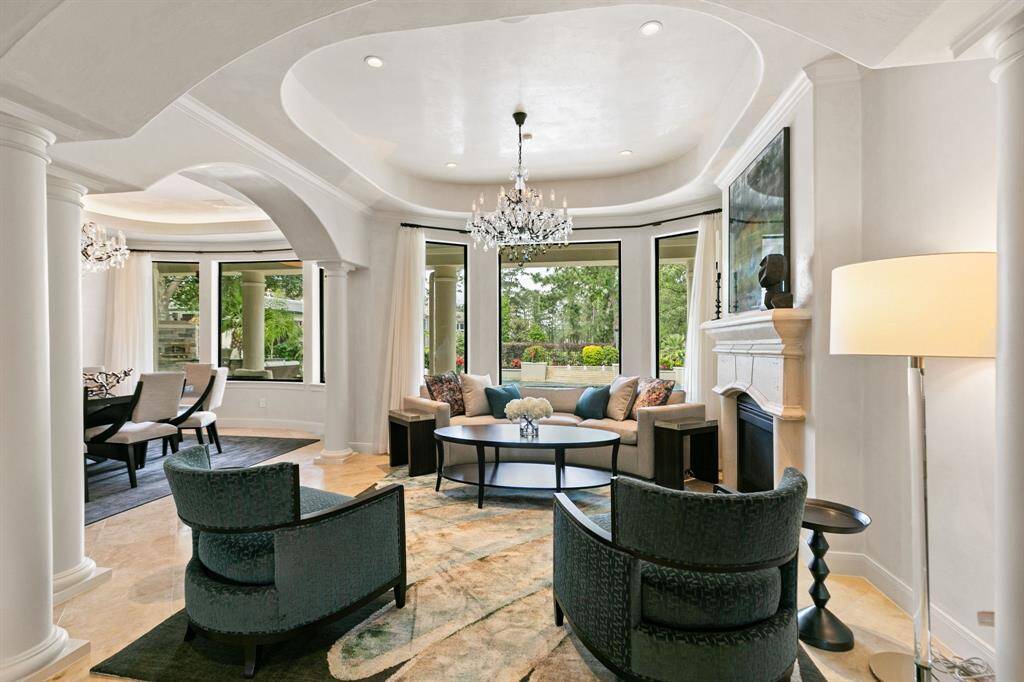 The formal living is so beautiful and includes plaster walls, a cast-stone fireplace and an elegant chandelier.