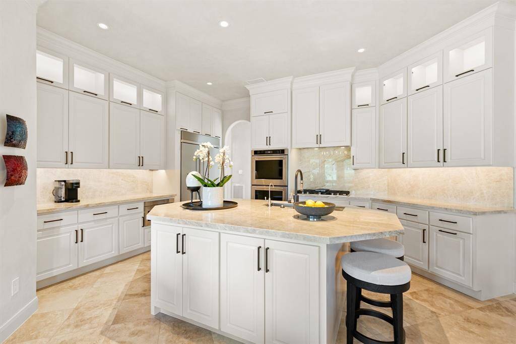 The kitchen is gorgeous and includes KitchenAid stainless-steel appliances (built-in refrigerator, double ovens, 5-burner gas cooktop) and a Sharp microwave.