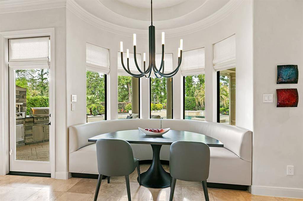 The breakfast room features elegant, built-in banquette seating and a fabulous contemporary chandelier.