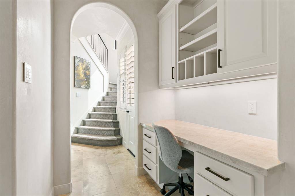 Behind the kitchen is a handy desk with storage and an access door to the driveway.  Notice the second staircase which leads directly to the home gym and residential data center.