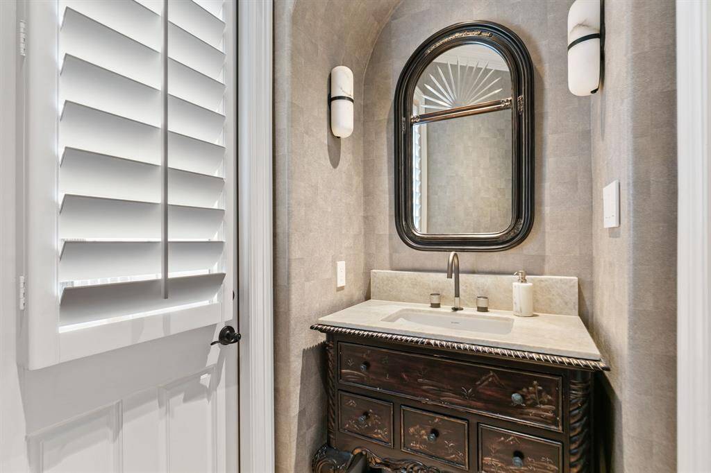 The stylish powder room also works well as the pool bath with the door leading to the backyard.
