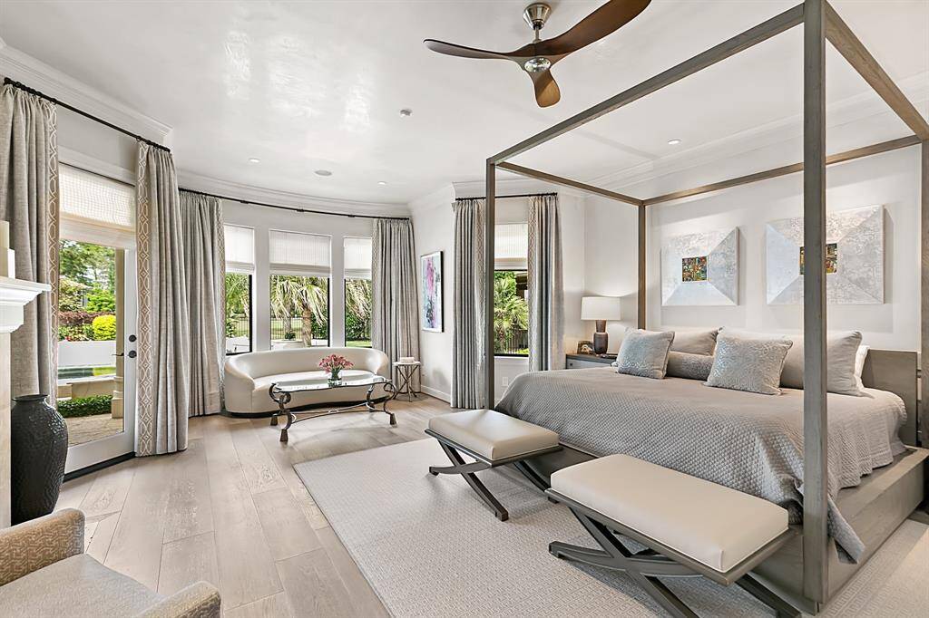 The primary suite is a dream!  Wood floors, fireplace, custom drapes and a door leading to the backyard.