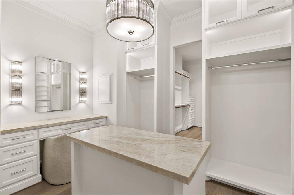 Stunning! The primary closets feature Taj Mahal Quartzite, ample storage and hanging space. and contemporary light fixtures.