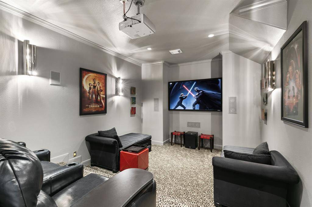 The media room features a projector and TV, sconce lighting and tiered seating.