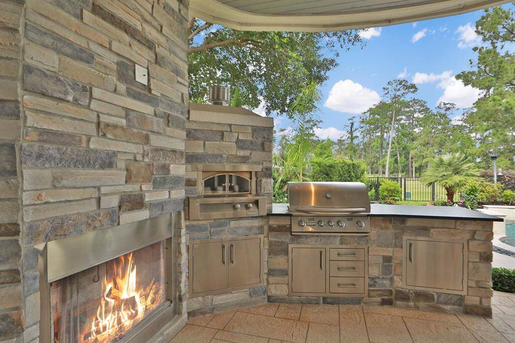 The outdoor entertainment area is fabulous! Enjoy the fireplace, covered patio, large fan, Alfresco pizza oven and Bullet barbecue grill. There are ample drawers for storing your grilling tools as well.
