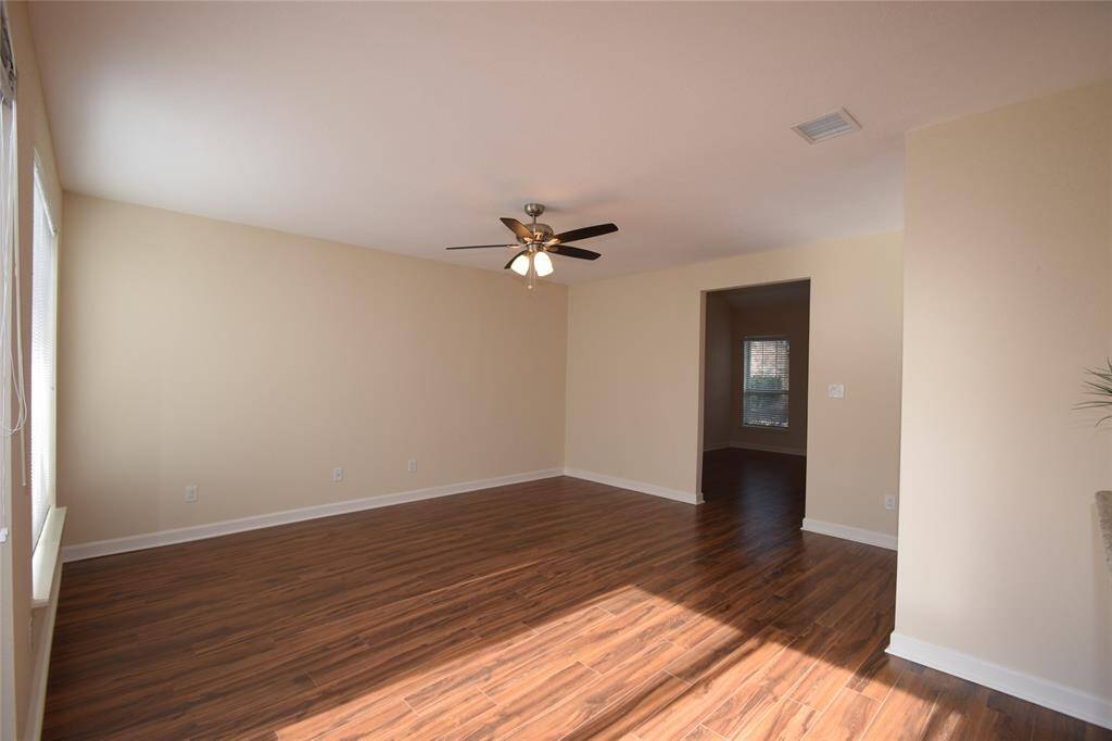 Family room featuring hardwood laminate floors and a ceiling fan with light fixture.