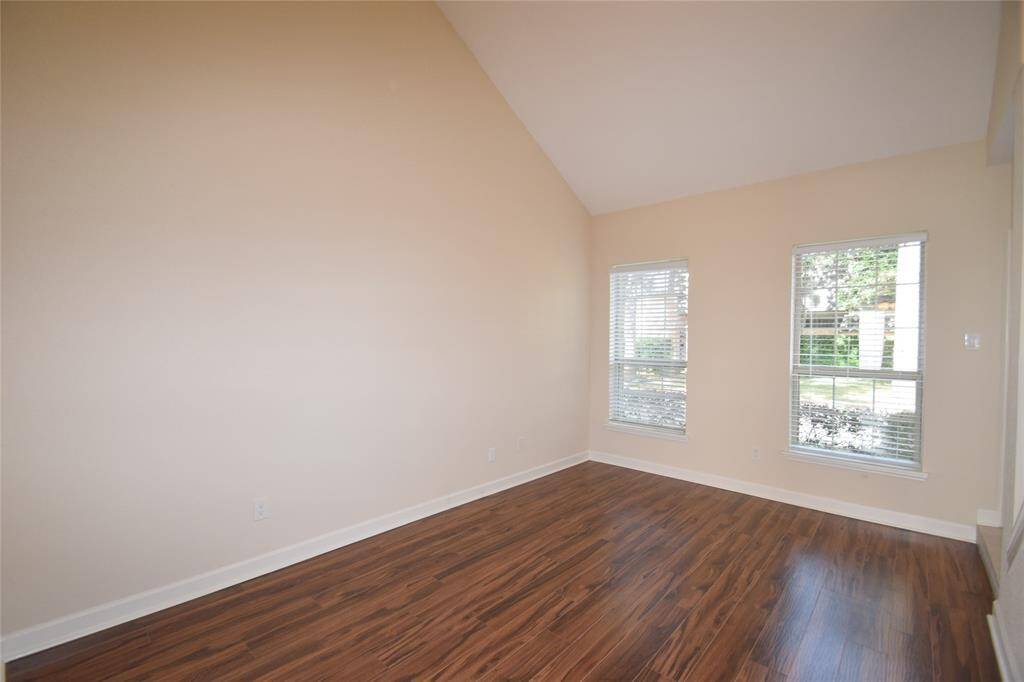 Living room or study accented by hardwood laminate floors and raised ceilings.