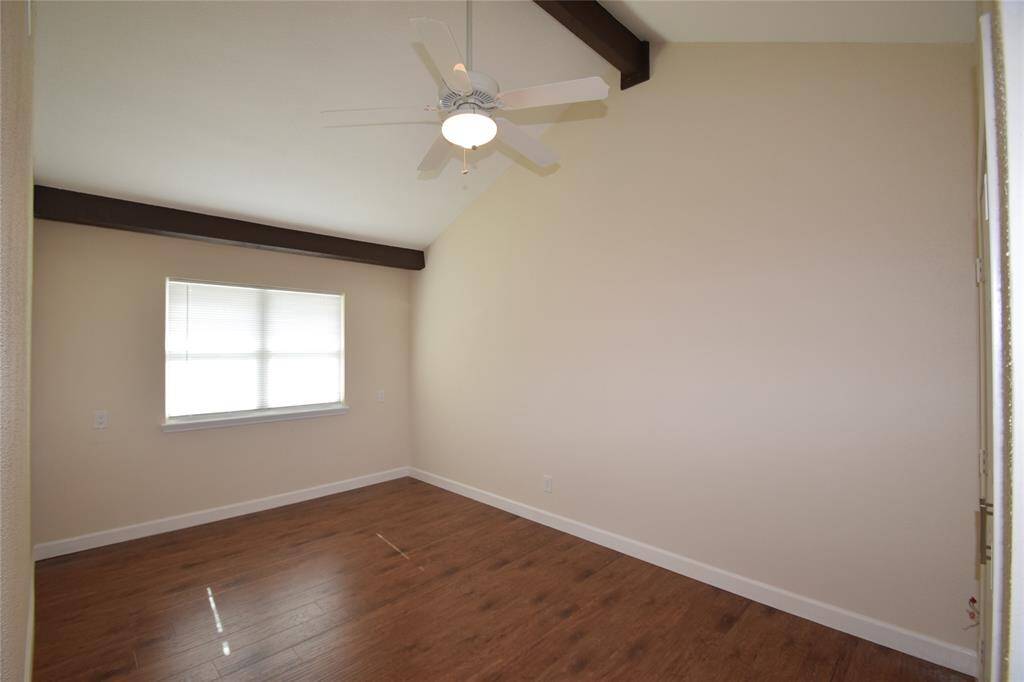 Bedroom upstairs offering hardwood laminate floors, raised ceilings with a beam accent, ceiling fan with light fixture, window blinds and nice closet space.