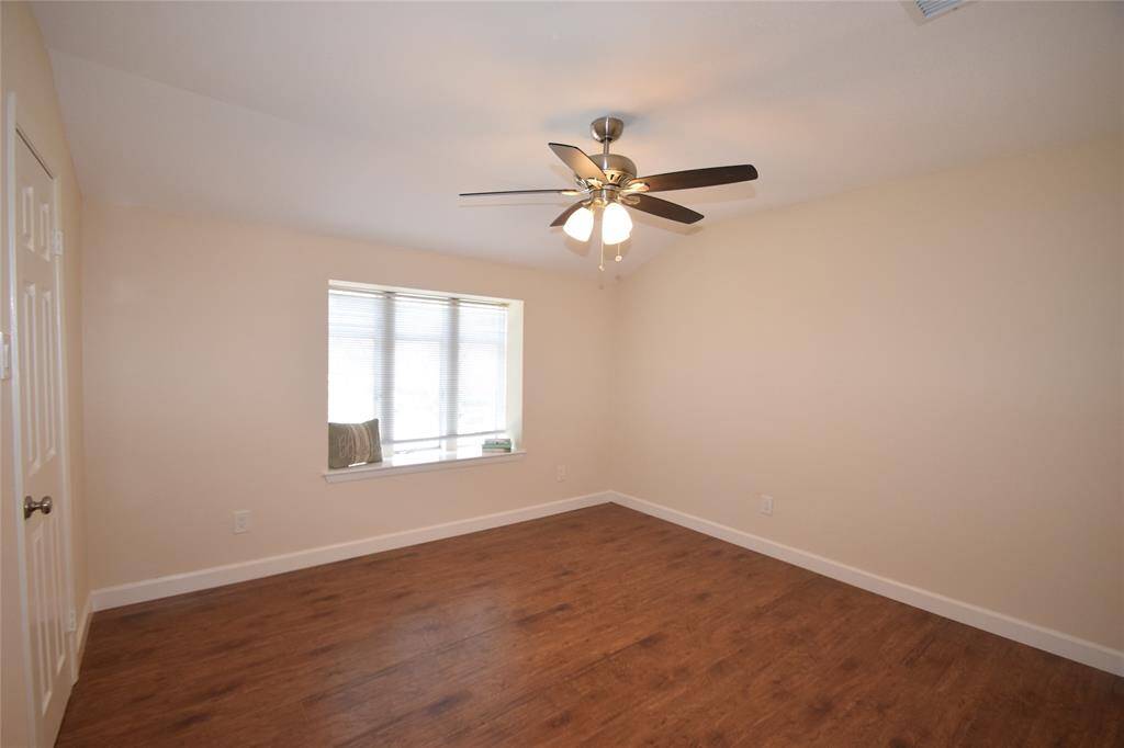Bedroom upstairs offering hardwood laminate floors, ceiling fan with light fixture, window blinds and nice closet space.