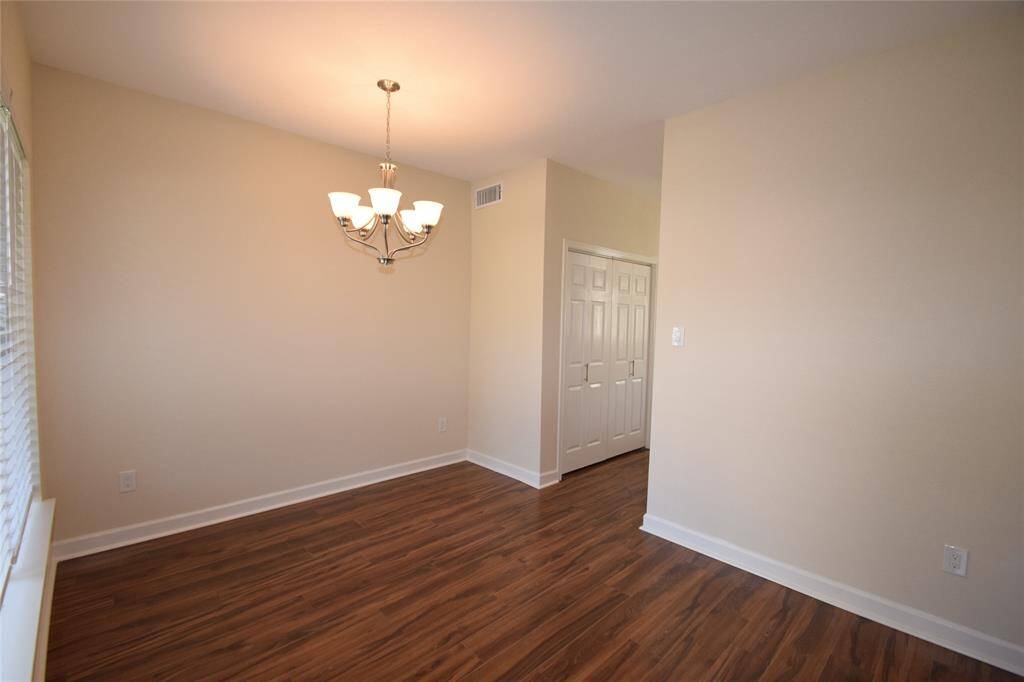 Dining room enhanced by hardwood laminate floors, storage closet and access to a half bath and kitchen.