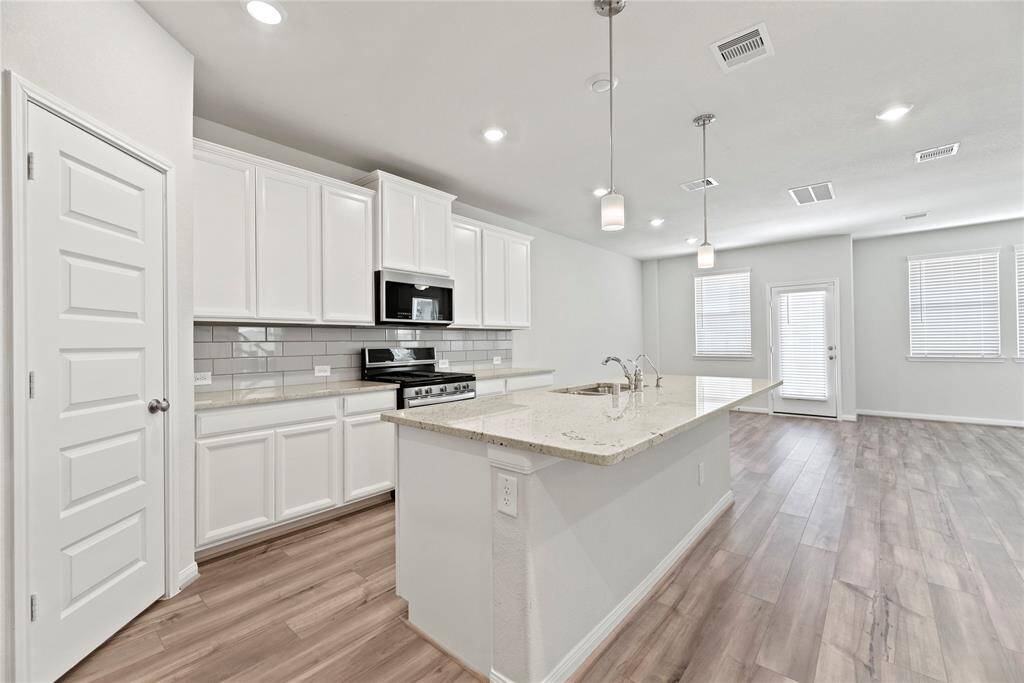 Another shot of the sleek kitchen. There is a walk-in pantry through the door.